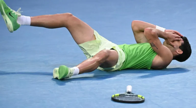 Carlos Alcaraz lays on the court in disbelief