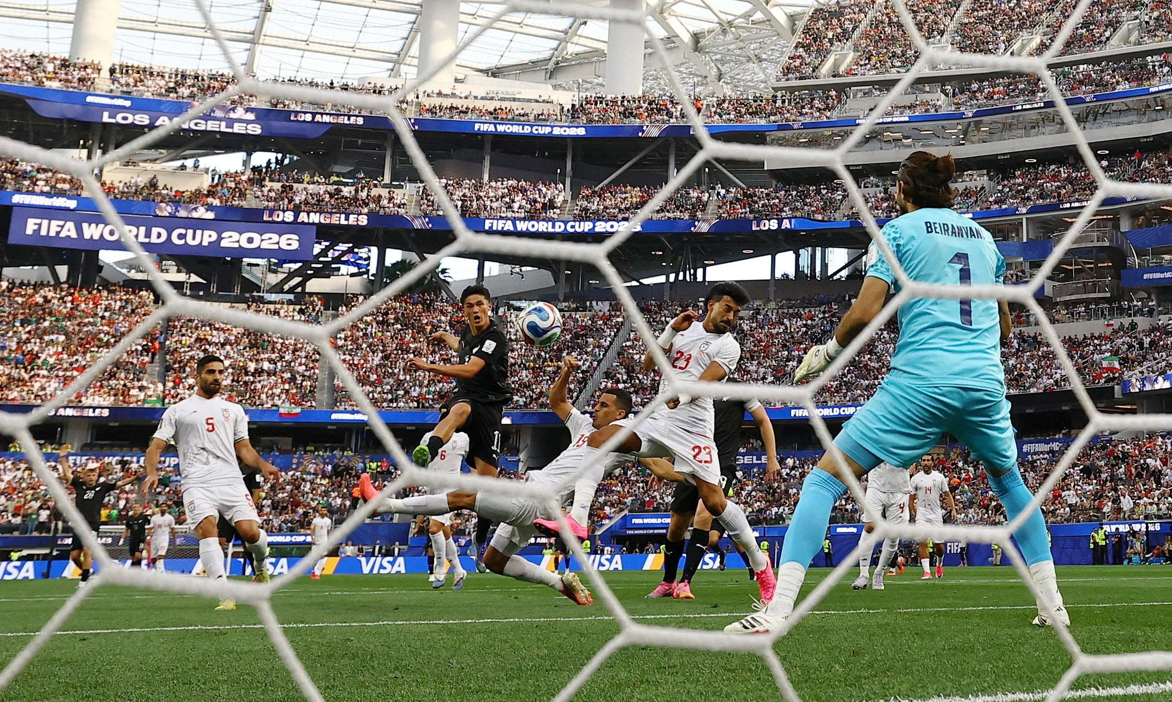 New Zealand’s Elijah Just thumps the ball past Iran’s keeper 