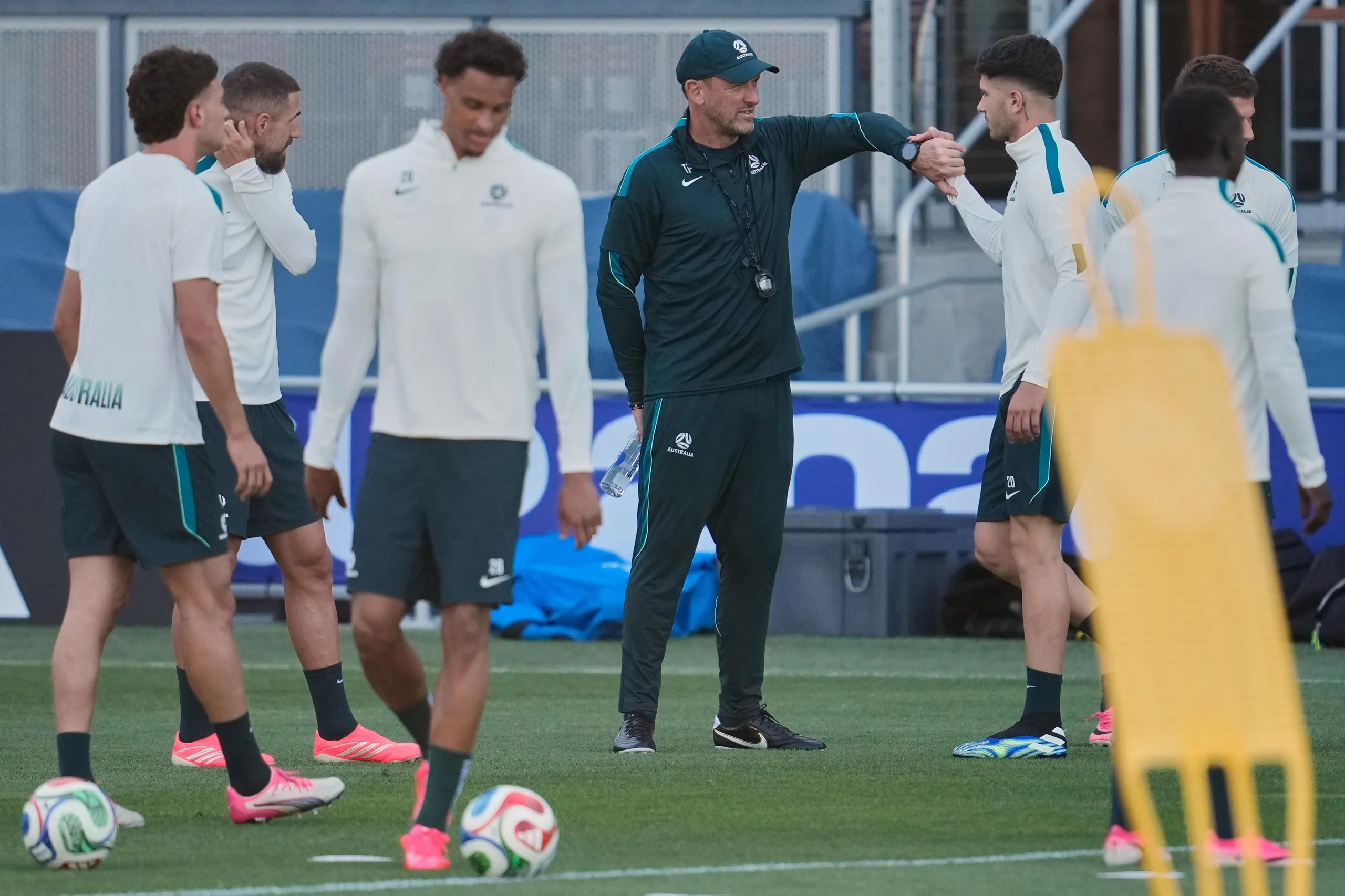 Socceroos head coach Tony Popovic talks with players in training during the World Cup