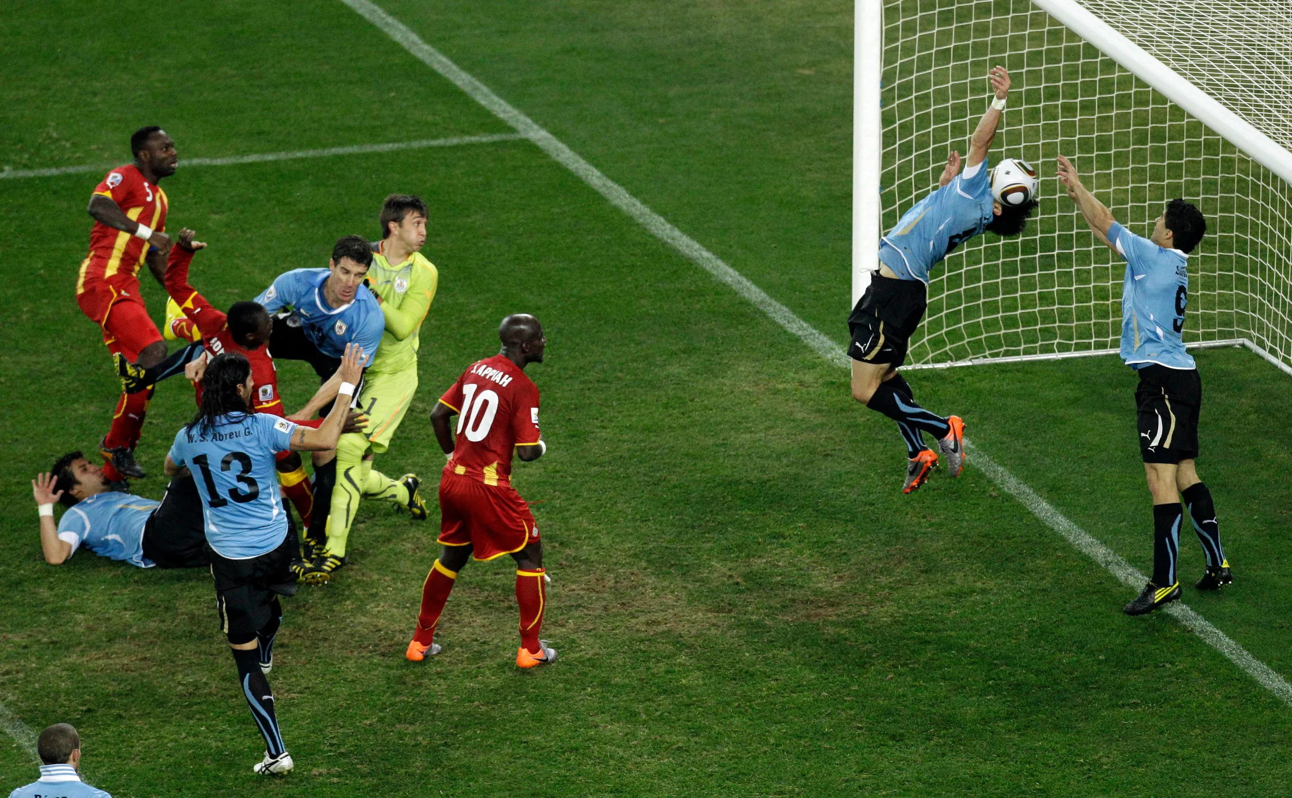 Luis Suárez (right) reaches his hands to the ball in front of goal