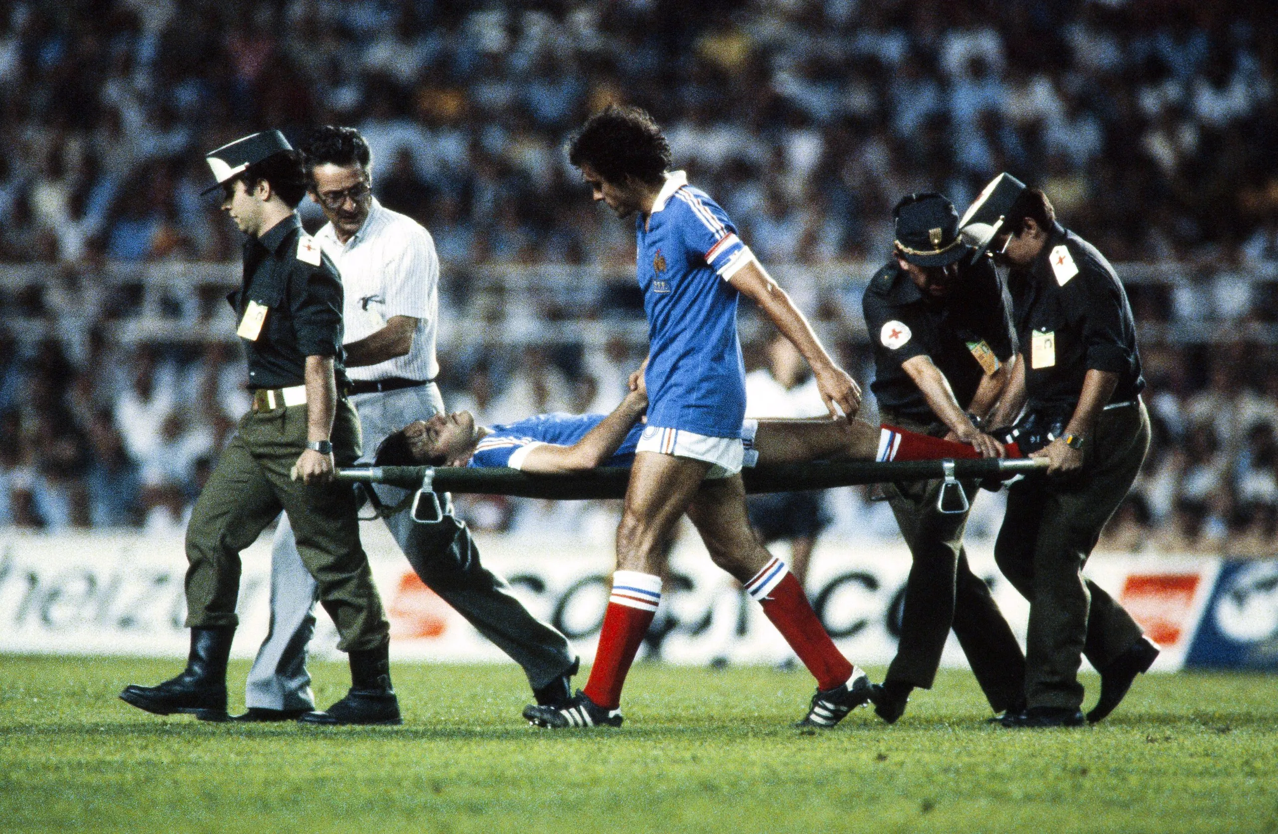 Michel Platini holds the hand of Patrick Battiston as he is carried off on a stretcher during France’s 1982 World Cup semi-final against West Germany