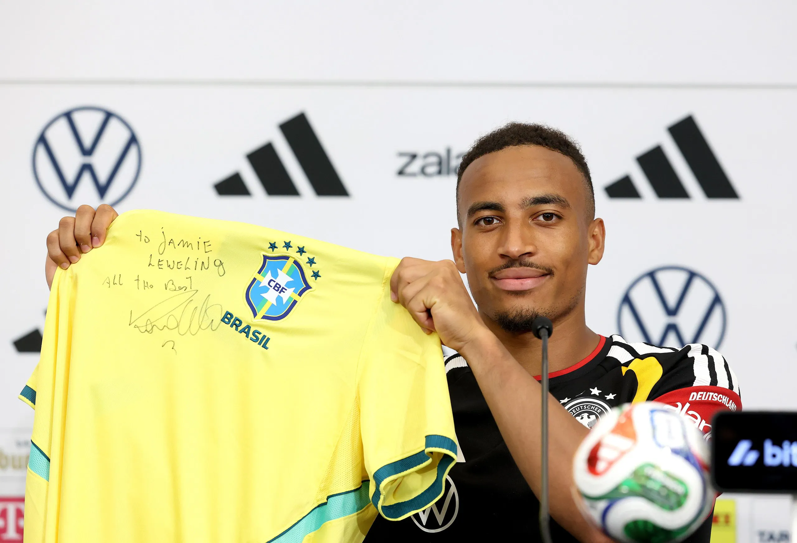 Jamie Leweling holding a Brazil shirt with a personal dedication from Ronaldo