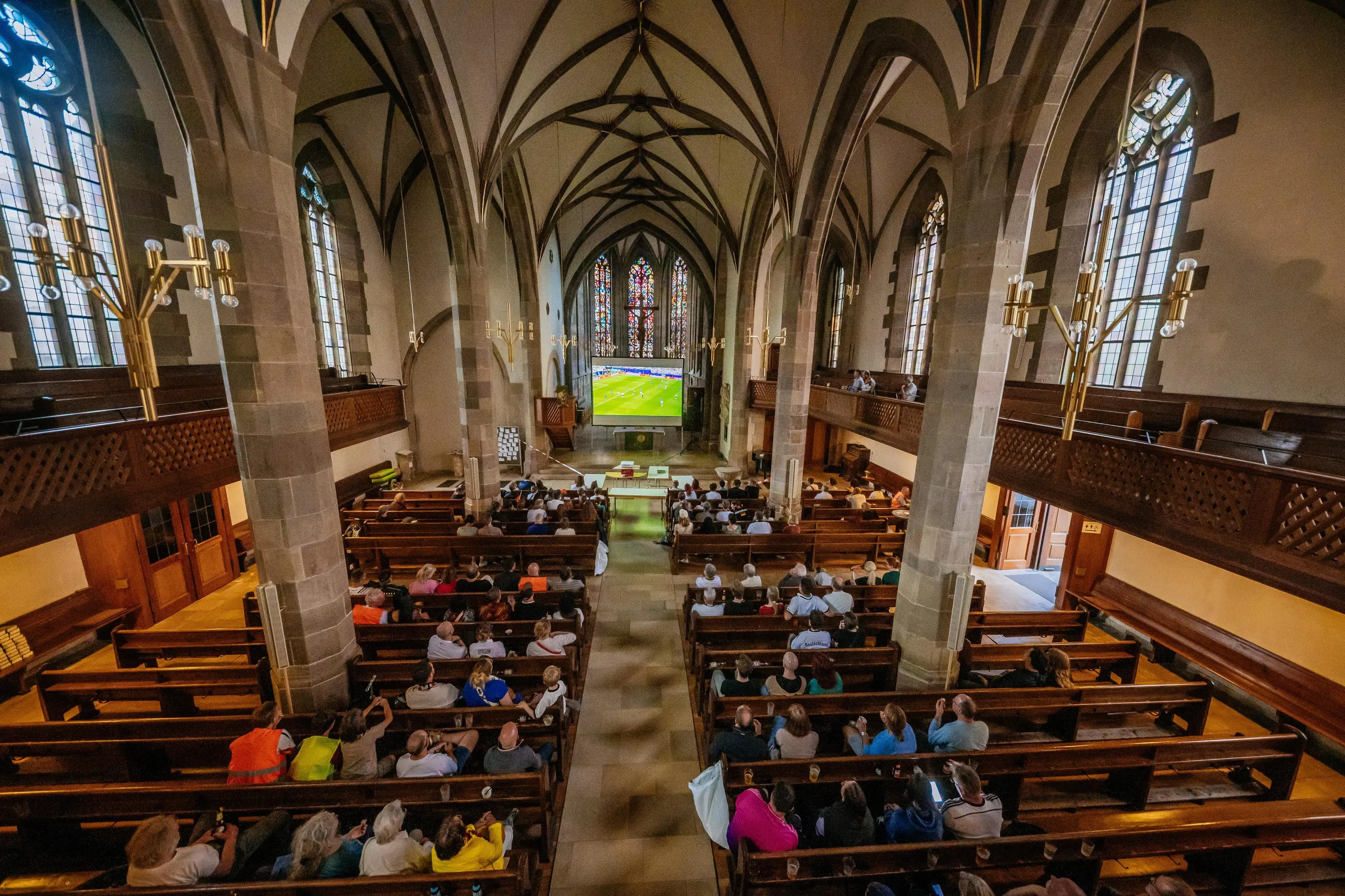 Football fans at a church in Bad Cannstatt, Stuttgart, Germany, watch the Group E match between Germany and Curacao.