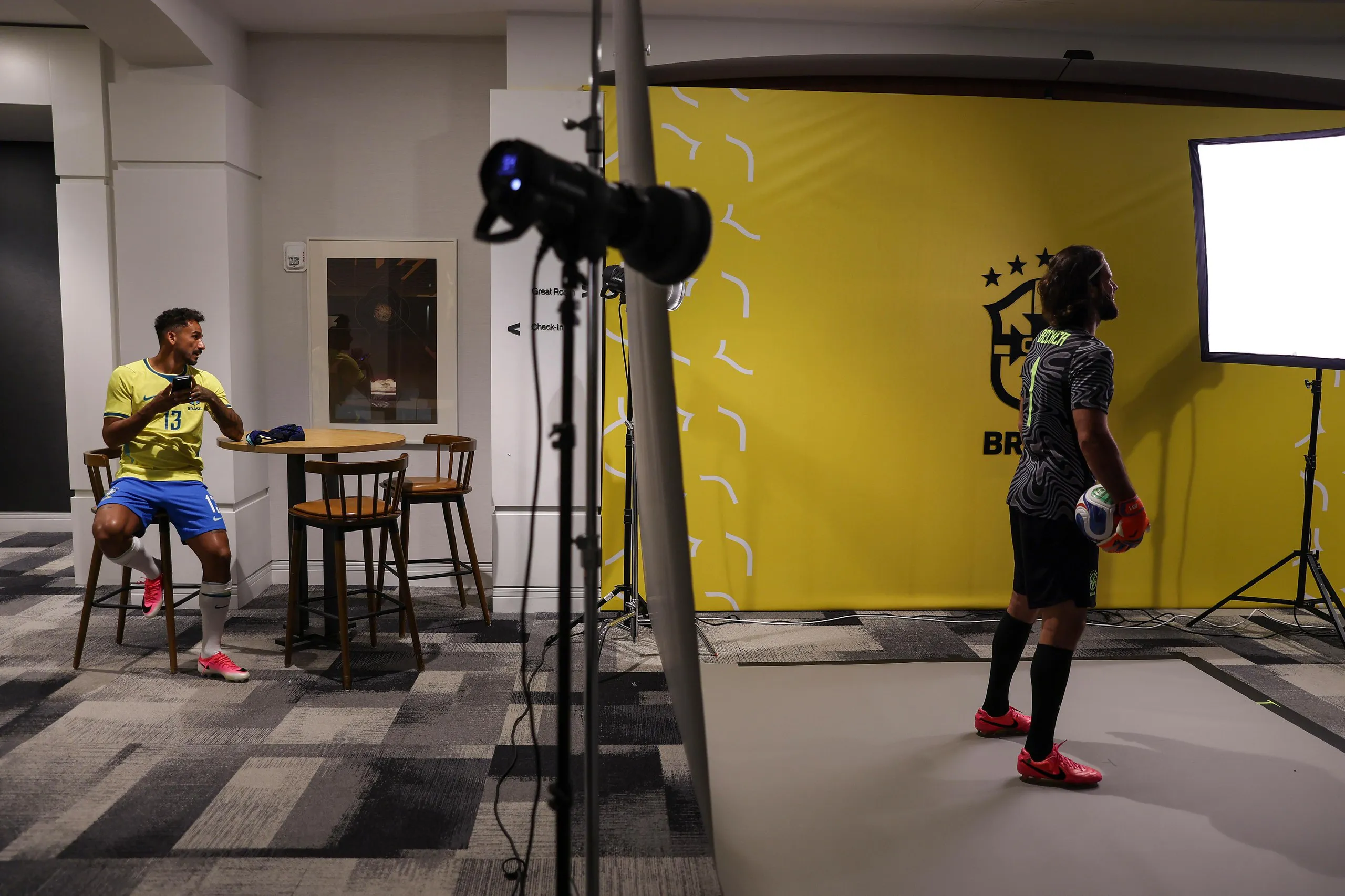 Danilo of Brazil waits as his compatriot Alisson poses for a picture in front of a softbox.