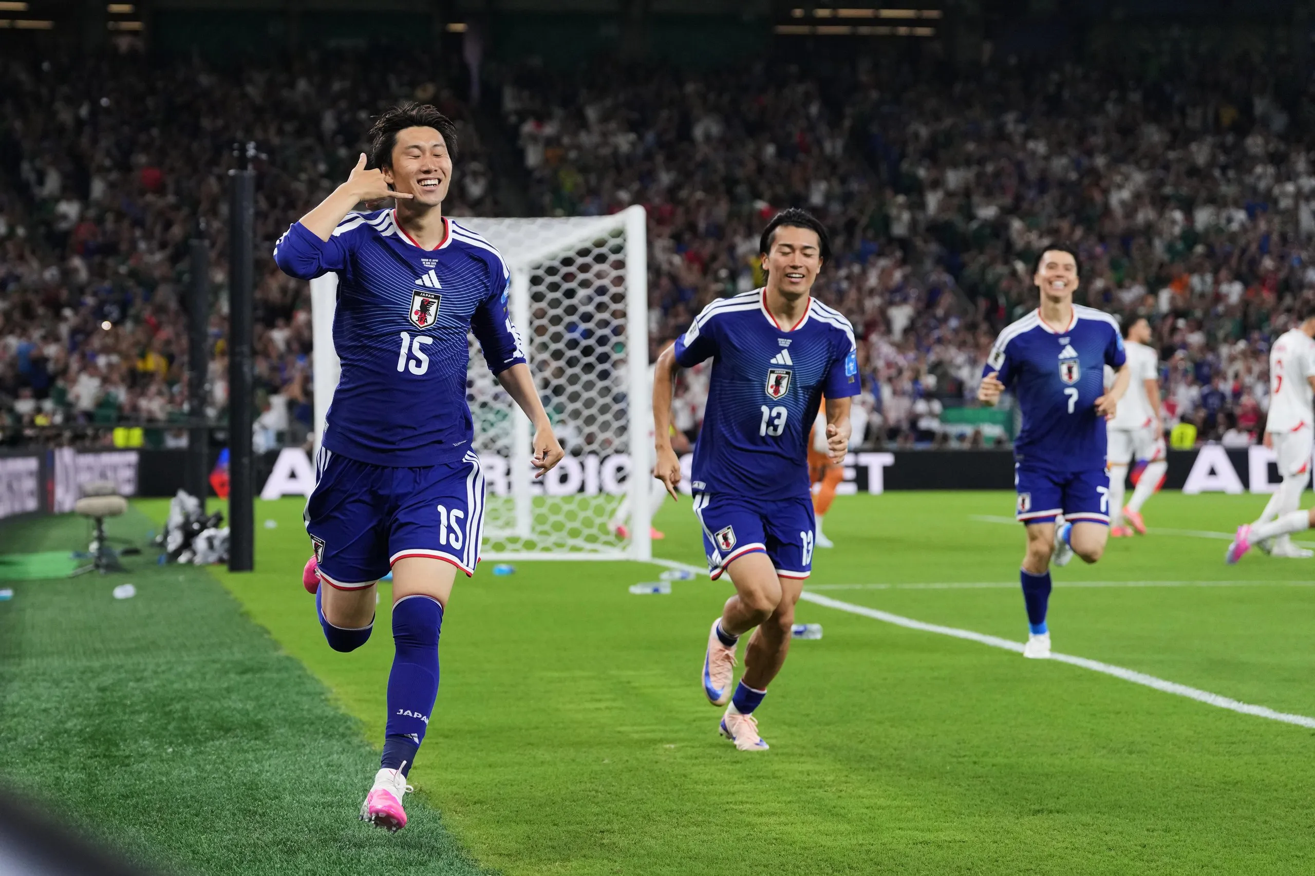 Daichi Kamada holds his right hand to his head as if taking a phone call to celebrate putting Japan 1-0 ahead