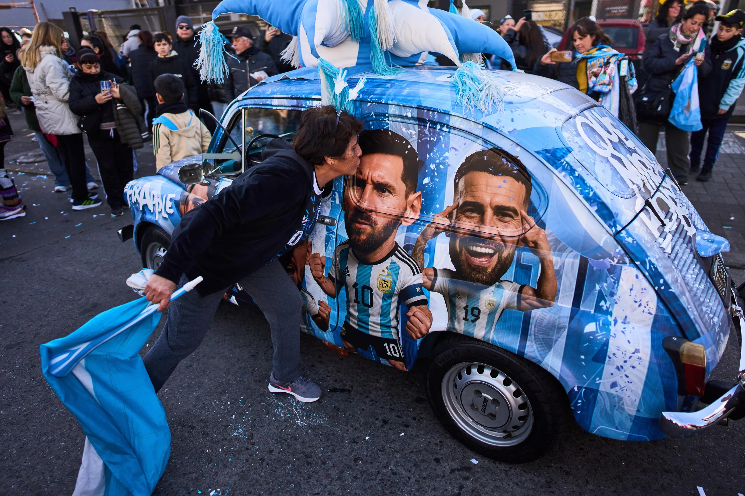 Fans kiss a car with Lionel Messi’s image on it in Argentina
