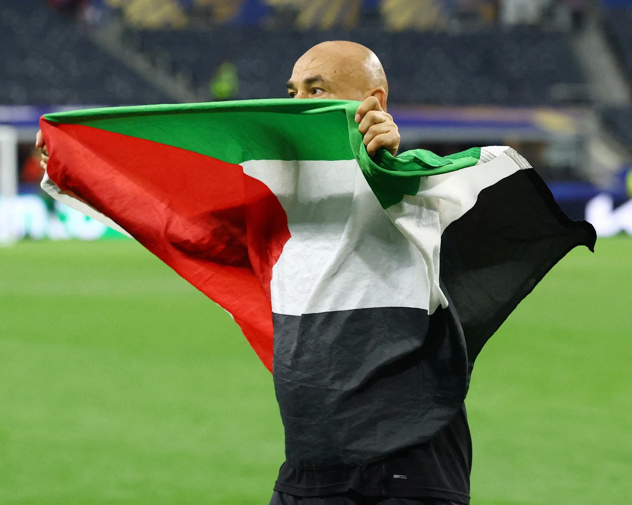 Hossam Hassan celebrates with a Palestine flag after Egypt defeated Australia on penalties.