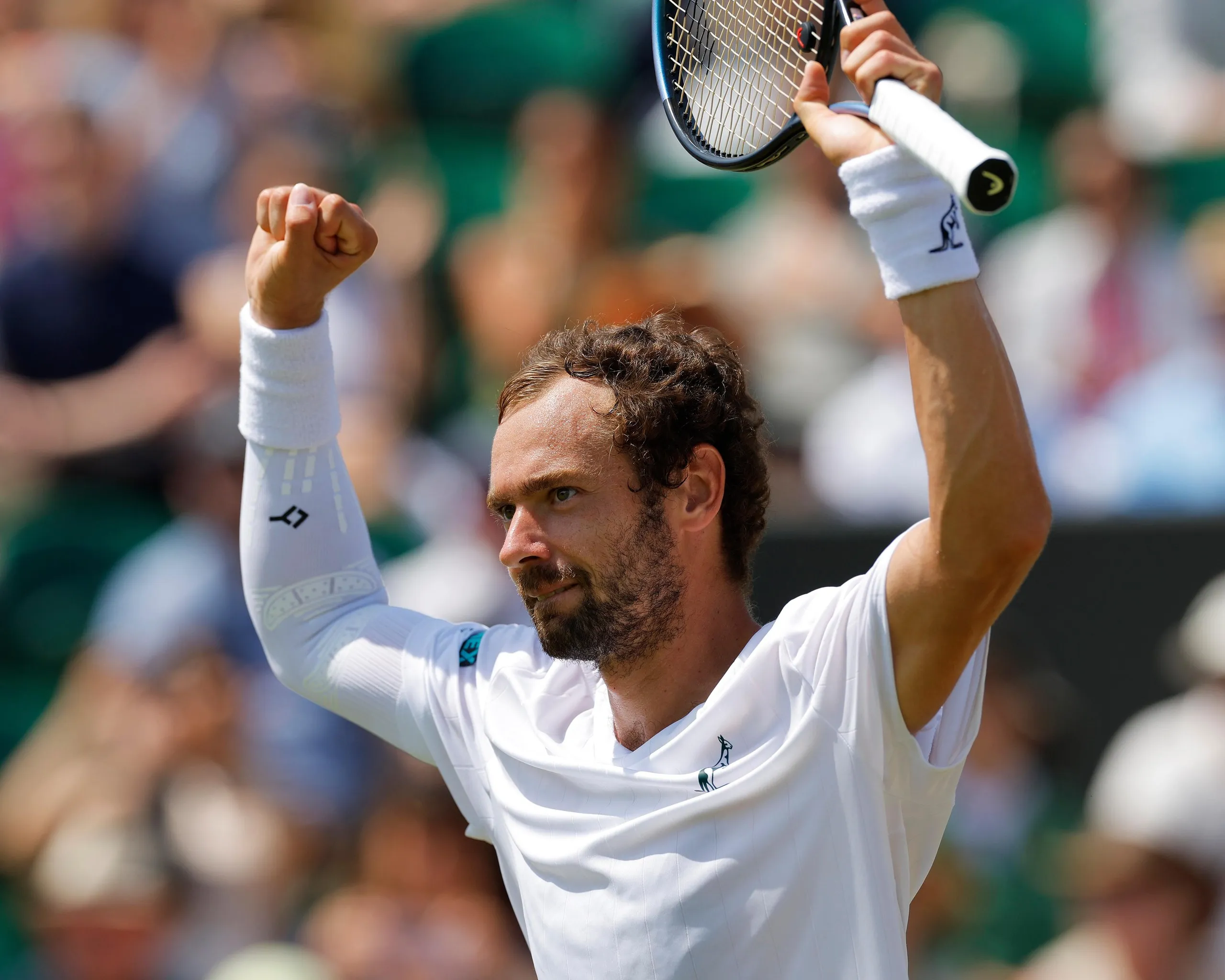 Roman Safiullin raises his arms in celebration after beating Joao Fonseca