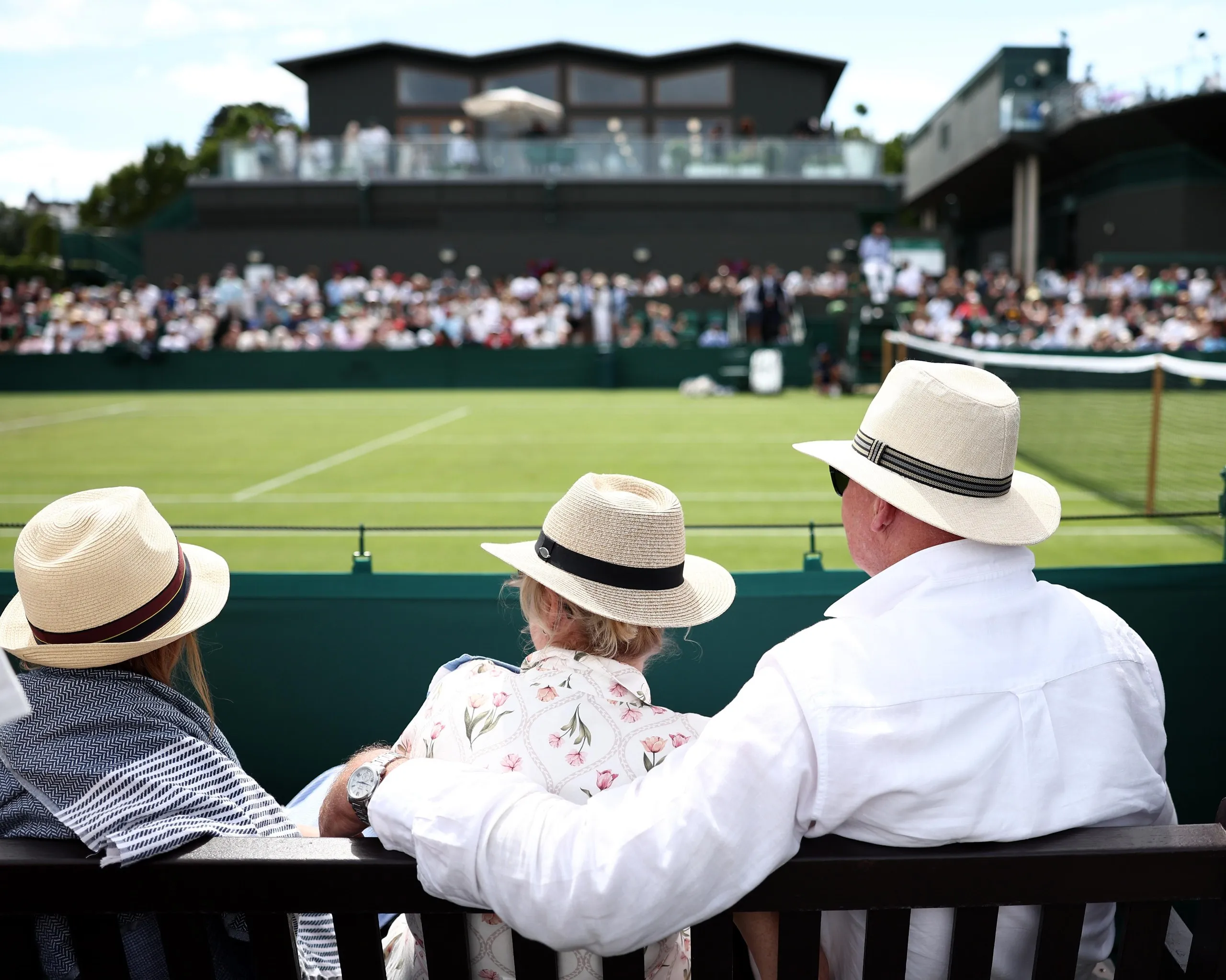 Spectators watch on the out courts at Wimbledon