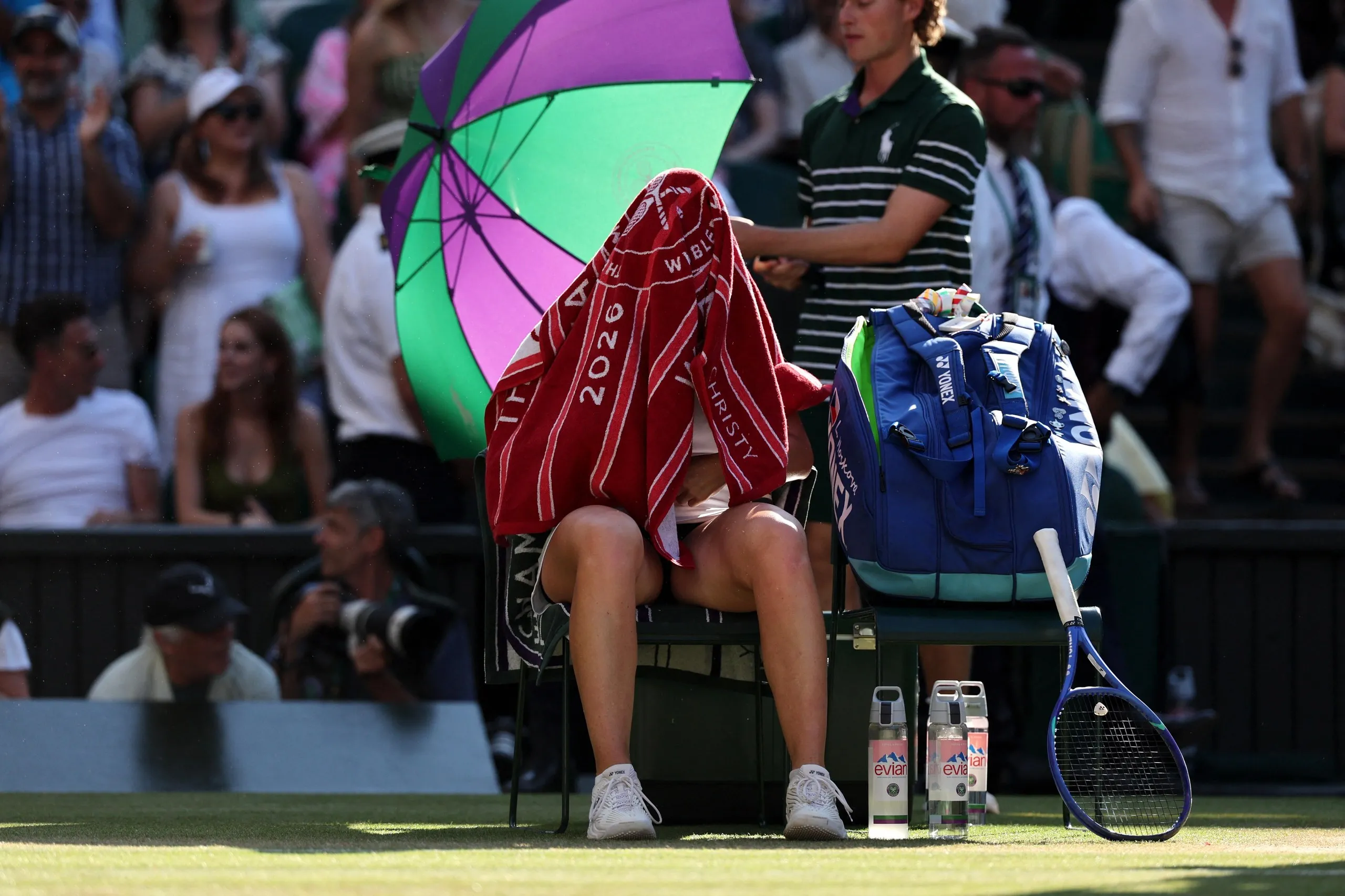Linda Noskova sits with a towel over head at a change of ends