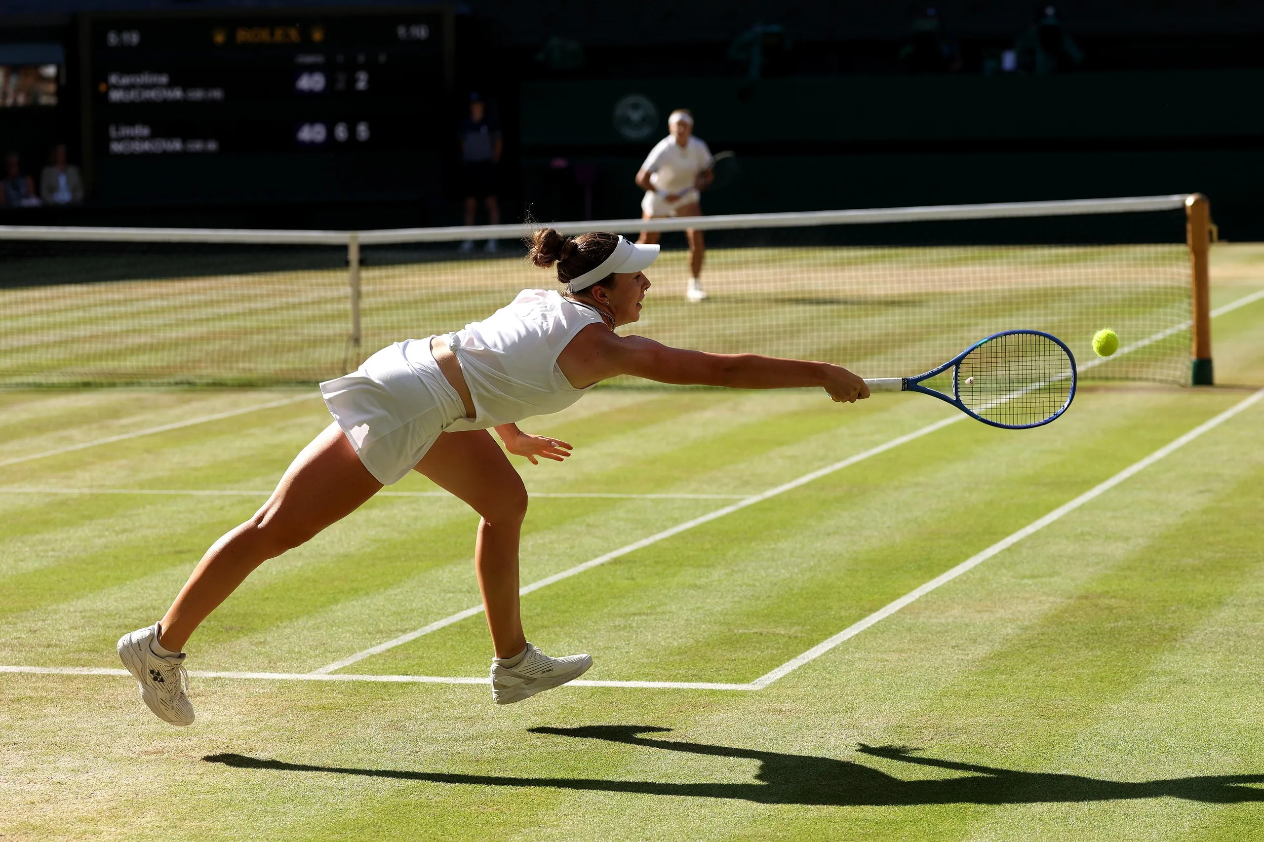 Linda Noskova stretches for a forehand off Karolina Muchova’s serve
