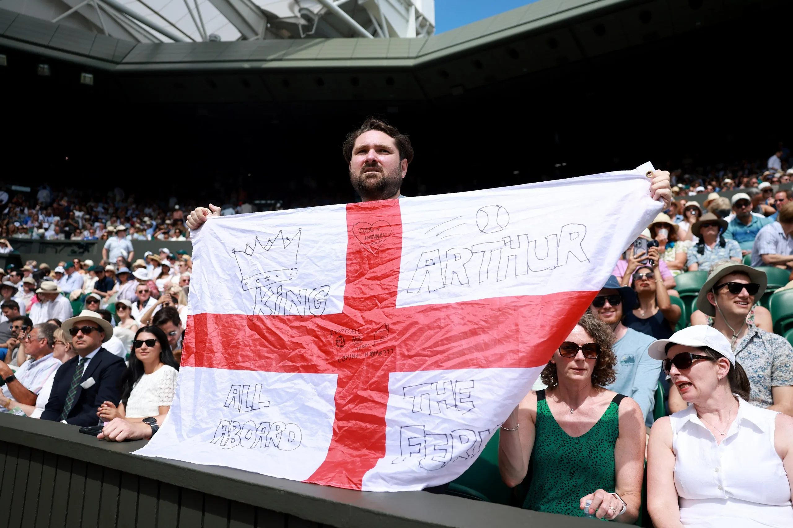 An Arthur Fery fan holds up an England flag on centre court.
