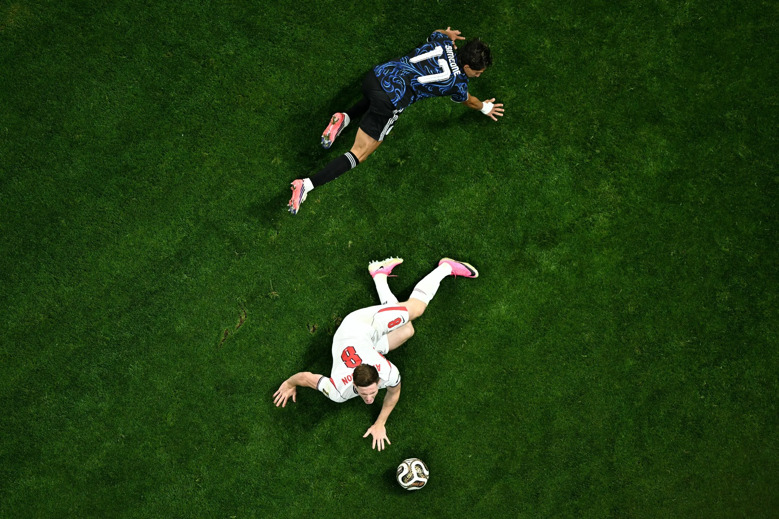 Elliot Anderson and Giuliano Simeone on the turf after contesting possession