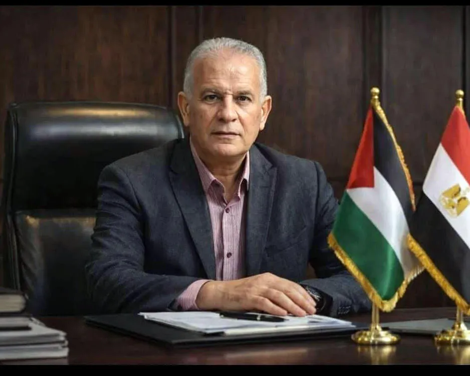 Mohamed al-Wahidi sitting at a desk with the Egyptian and Palestinian flags on it